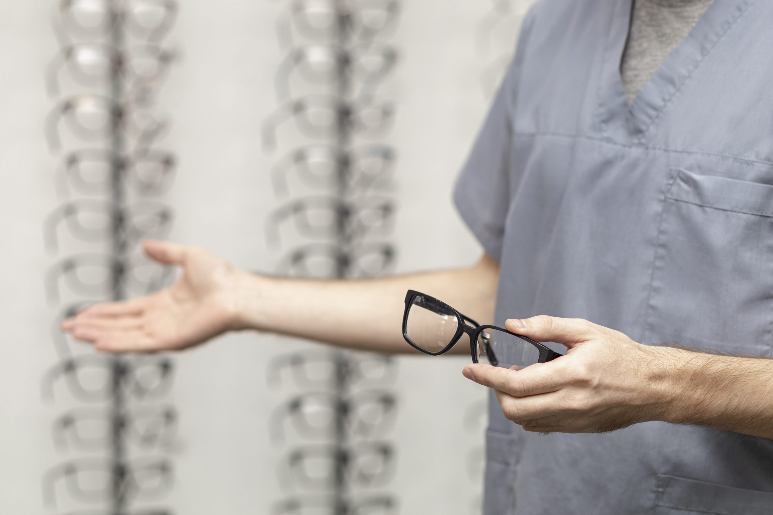 side-view-man-holding-pair-glasses-hand-showing-other-pair-with-other-hand